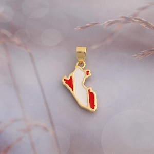 Op de afbeelding: Een goudkleurige metalen hanger in de vorm van de kaart van Peru, voorzien van rood en wit emaille. De hanger heeft een klein goudkleurig oogje aan de bovenzijde voor bevestiging aan een ketting en heeft een gepolijste, glanzende afwerking.