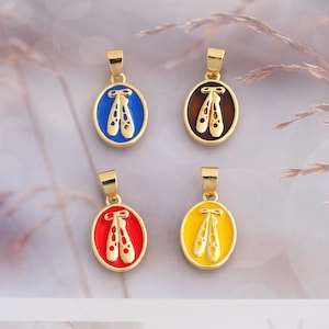 May include: Four oval-shaped gold-tone metal pendants, each featuring a central cutout design of ballet slippers. The pendants have colorful enamel backgrounds in blue, brown, red, and yellow, with a small gold loop at the top for attachment.