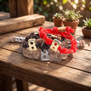 May include: A collection of bracelets with the number eight as a focal point. The bracelets are made of rope in various colors, including red, brown, and beige. Some bracelets have gold or silver number eight charms.