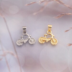 May include: Two bicycle-shaped pendants, one in a silver-tone finish and one in a gold-tone finish. Each pendant features a detailed frame, two spoked wheels, and a small loop at the top for attachment to a necklace chain or jewelry finding.