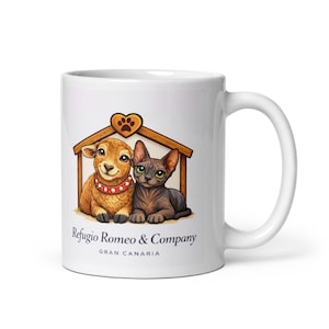 Puede incluir: Taza de cerámica blanca con una ilustración de dibujos animados de una oveja y un gato dentro de una caseta de madera. La oveja lleva un collar rojo y el gato tiene ojos verdes. El texto "Refugio Romeo & Company GRAN CANARIA" está impreso debajo.