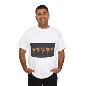 以下が含まれることがあります： 「HEART FILLED BULBS」の文字と、それぞれ異なる段階で点灯する6つのハート型の電球のグラフィックがプリントされた白いTシャツ。各電球の下にはテキストがあります。人物は黒いズボンを着用しています。