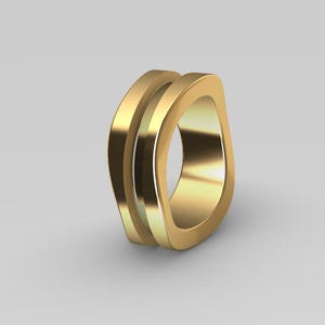 May include: A gold-colored ring with a smooth, polished finish and a distinct, non-circular, organic shape. The band features a double-layered design with a central groove running along the outer circumference, creating a layered appearance.