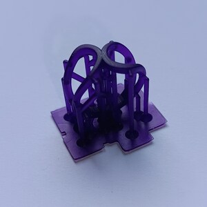 May include: A translucent purple 3D printed object featuring a flat square base with four circular cutouts and a central vertical structure composed of four curved, interconnected arch-like elements that meet at the top center point.