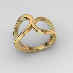 Peut inclure: Une bague dorée au design unique et fluide. La bague présente deux bandes incurvées entrelacées qui créent une forme ouverte et abstraite. La bague est faite d'un matériau métallique brillant.