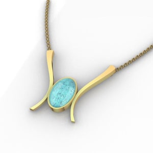 May include: A gold necklace featuring a central oval-shaped light blue stone with a speckled texture. The stone is held by two curved gold arms that extend outward, connecting to a delicate gold chain on each side of the pendant structure.