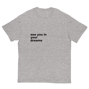Peut inclure: T-shirt gris chiné avec l'inscription noire "see you in your dreams". Le t-shirt a des manches courtes et un col rond.