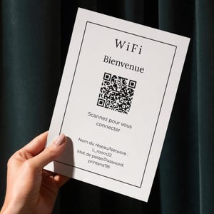 Puede incluir: Una tarjeta blanca con la palabra "WiFi" y "Bienvenue" impresas en negro. Incluye un código QR e instrucciones para escanear y conectarse. El nombre de la red es L_room22 y la contraseña es printens78!