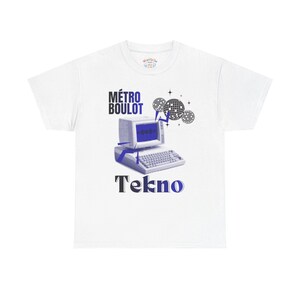 Peut inclure: T-shirt blanc avec un motif d'ordinateur rétro bleu et noir, avec le texte "MÉTRO BOULOT Tekno". Le design comprend des illustrations de boules disco, créant une esthétique vintage inspirée de la technologie.