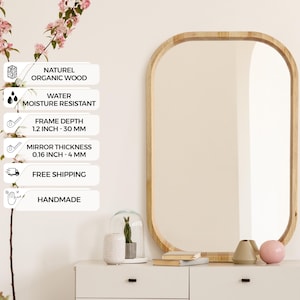 Könnte beinhalten: Ein rechteckiger Spiegel mit abgerundeten Ecken, eingerahmt in hellem Holz, hängt über einer weißen Kommode. Der Spiegel ist mit "Natural Dark" und "Handmade" beschriftet. Die Rahmentiefe beträgt 30 mm, und die Spiegelstärke beträgt 4 mm.