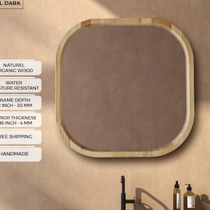 Peut inclure: Un miroir carré aux coins arrondis avec un cadre en bois clair. La profondeur du cadre du miroir est de 30 mm et l'épaisseur du miroir est de 4 mm. Le texte "NATURAL DARK" est en haut. Le miroir est fait à la main.