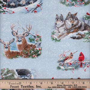 May include: A blue and white fabric with a wintery woodland scene. The fabric features deer, wolves, bears, cardinals, and chickadees. The fabric is covered in a light dusting of snow.