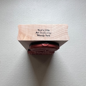 May include: A wooden block stamp with a red rubber stamp attached. The block is labeled "York's Little Art Studio Essy Wendy York".
