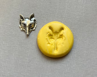 May include: A silver fox head charm and a yellow silicone mold of a fox head.