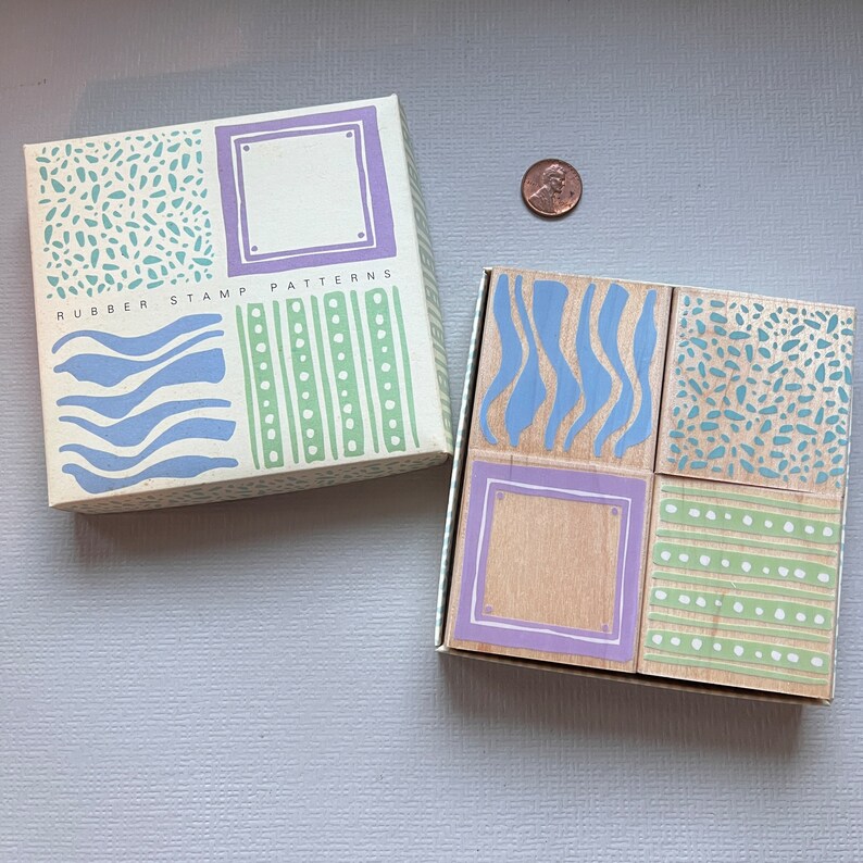 May include: A set of four wooden rubber stamps with different patterns. The stamps are arranged in a 2x2 grid. The patterns include waves, stripes, dots, and a blank space. The stamps are labeled "Rubber Stamp Patterns".