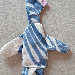 Peut inclure: Poupée oiseau en tissu faite à la main, avec un corps rayé bleu et blanc, des ailes blanches et des pieds et un bec roses. La poupée est en tissu doux et a un design fantaisiste, idéal pour un jouet d'enfant ou une décoration de chambre d'enfant.