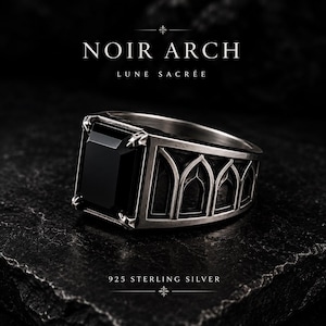 May include: A 925 sterling silver ring featuring a large, rectangular black stone set in a band with an architectural arch design. The text NOIR ARCH LUNE SACRÉE and 925 STERLING SILVER is visible in the image, highlighting the metal composition.