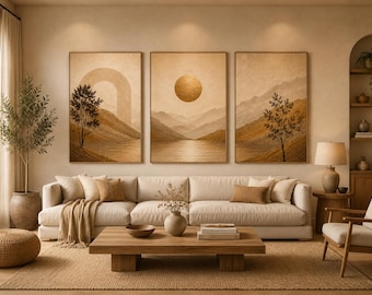 May include: Three framed landscape art prints in warm tones hang above a cream-colored sofa. The prints depict mountains, trees, and a sun. A wooden coffee table, rug, and decorative items complete the living room setting.