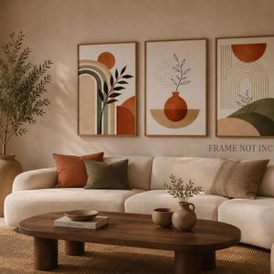 Op de afbeelding: Een set van drie wandkunstprints met abstracte geometrische vormen, bogen en botanische lijntekeningen in terracotta, saliegroen en beige tinten. De tekst FRAME NOT INCLUDED is zichtbaar op de afbeelding weergegeven.