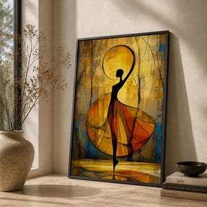 May include: A framed rectangular wall art print featuring a stylised silhouette of a dancer in a flowing orange and yellow dress. The figure is positioned against a golden abstract background with dark tree-like lines and a circular halo shape above.