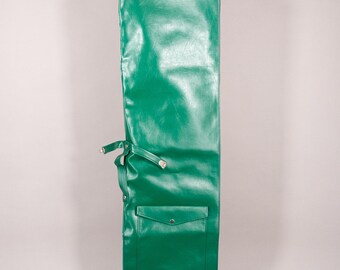 Puede incluir: Una bolsa rectangular verde brillante con un bolsillo y cierres de correa. La bolsa está hecha de un material de cuero sintético brillante. La bolsa tiene un bolsillo en la parte delantera y una correa con herrajes metálicos. La bolsa está diseñada para guardar un objeto largo y estrecho.