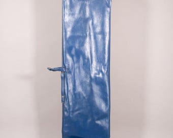 Puede incluir: Una bolsa larga y rectangular de vinilo azul con cierre de cremallera y asa. La bolsa es de color azul vibrante y parece estar hecha de un material duradero. Tiene un asa lateral y una correa con hebilla.