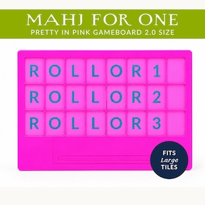 Op de afbeelding: Een felroze spelbord met de tekst "ROLLOR 1", "ROLLOR 2" en "ROLLOR 3" in blauw. Het spelbord heeft bovenaan de tekst "MAHJ FOR ONE" en "PRETTY IN PINK GAMEBOARD 2.0 SIZE". Een marineblauwe cirkel met de tekst "FITS Large TILES" staat onderaan.