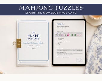 May include: A stack of white paper with blue text reading MAHJ FOR ONE Gameboard & Strategy Puzzles 2026 NMJL Card Practice held by a gold binder clip, next to a tablet displaying Puzzle 7 with mahjong tile illustrations and text.