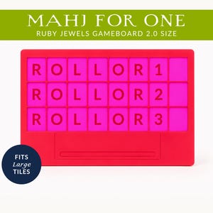Op de afbeelding: Een rood Mahjong-bord met roze vierkanten met de tekst "ROLL OR 1", "ROLL OR 2" en "ROLL OR 3". De tekst "MAHJ FOR ONE" en "RUBY JEWELS GAMEBOARD 2.0 SIZE" staan bovenaan. Een blauwe cirkel leest "FITS Large TILES".