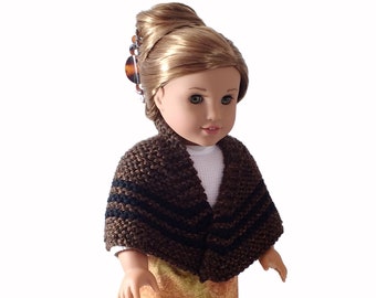 May include: A brown and black striped knitted shawl for a doll. The shawl is worn by a doll with blonde hair and a yellow skirt.