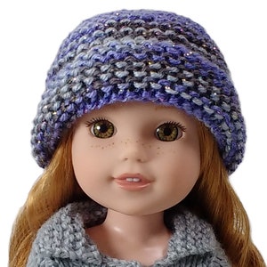 May include: A doll wearing a blue and purple knitted hat with a grey knitted sweater.