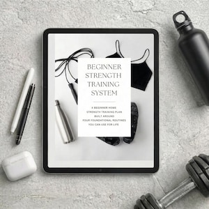 May include: A digital tablet displays a "Beginner Strength Training System" plan, with a black sports bra, jump rope, and water bottles. A dumbbell and wireless earbuds are also visible, suggesting a fitness theme.