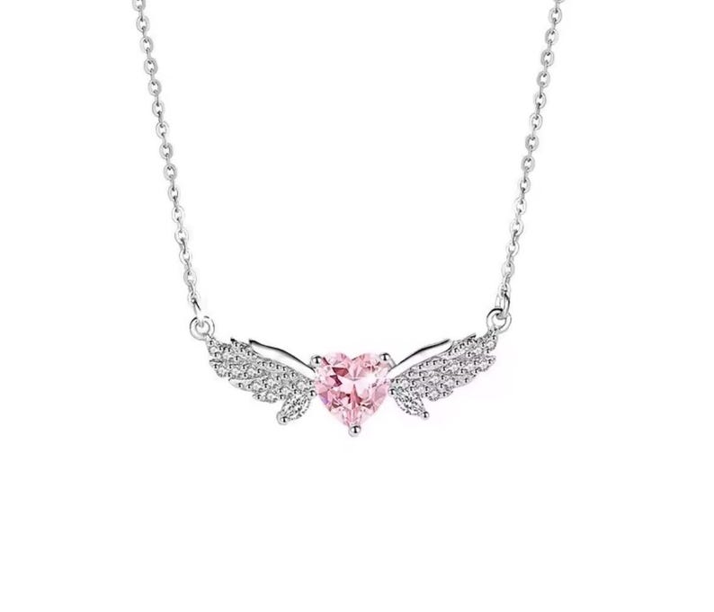 Może przedstawiać: Srebrny naszyjnik z r&oacute;żową zawieszką w kształcie serca i skrzydłami wysadzanymi kryształami. Zawieszka wisi na delikatnym łańcuszku, tworząc romantyczny i elegancki dodatek. Naszyjnik jest na białym tle.