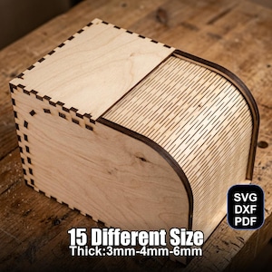 May include: A wooden box with a sliding lid, featuring intricate laser-cut details and a curved side. The box is made of light-colored wood and has the text "15 Different Size Thick: 3mm-4mm-6mm" and "SVG DXF PDF" on the side.