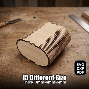 Puede incluir: Una caja de madera de color claro con forma ovalada y diseño cortado con láser. La caja tiene tapa y está hecha de varias capas de madera. El texto de la imagen dice "15 Different Size" y "Thick:3mm-4mm-6mm".