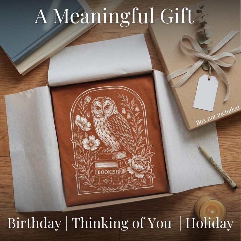 May include: A rust-colored t-shirt with a white owl illustration, flowers, and the word "BOOKISH" is presented in an open gift box. 
Bookish Shirt Comfort Colors Premium Tee Women Book Lover Gift Literary Reader Present Dark Academia Aesthetic Vintage Owl Graphic Design Linocut Botanical Style Stacked Books Pattern Booktok Community Wear Book Club Outfit Reading