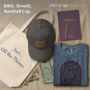 The words " Bible. Bronte. Baseball Cap" appear  with a collection of items offered by Life x dESign Studio Co.  - A tote bag, a digital phone wallpaper design, a custom journal, a reading enthusiast tee.