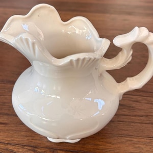 May include: A set of three ceramic mugs with a speckled, matte finish. Each mug features a different color: light blue, cream, and gray. The mugs have a simple, modern design and a comfortable handle.