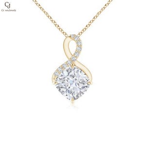 May include: A gold-colored pendant necklace featuring a large, square-cut, clear gemstone. The pendant has an infinity symbol design, with small, clear gemstones set along one side. The necklace chain is also gold-colored.