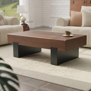 May include: A rectangular coffee table featuring a thick, solid wood top with a rich brown grain and a smooth finish. The table is supported by two sturdy, matte black metal slab legs positioned at each end, providing a stable base.
