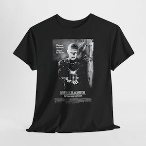 May include: Black t-shirt featuring a black and white image from the movie Hellraiser. The image includes a character with pins in their head, the movie title, and the text "Demon to some. Angel to others."