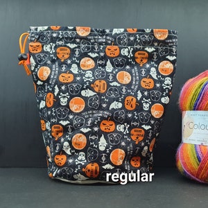 Può includere: Borsa a cordoncino nera e arancione a tema Halloween. La borsa è ricoperta da un motivo ripetitivo di personaggi di Star Wars, zucche e il testo "These are not the treats you're looking for".