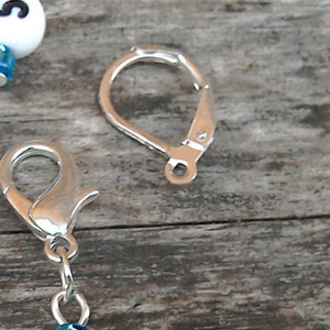 May include: Two silver-toned earring hooks. One hook is a simple loop, the other is a lobster claw clasp.