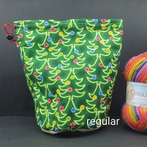 May include: Green drawstring project bag with a Christmas tree and ornament pattern. The bag is labeled "regular".