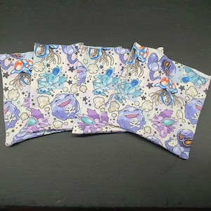 May include: Five white fabric pouches with a pastel purple, blue, and pink print of cartoon characters. The pouches feature a repeating pattern of stars and clouds.