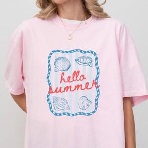 Maglietta Hello Summer Shell, maglietta per vacanze al mare, maglietta con grafica a tema marino, maglietta regalo per un viaggio estivo tropicale, maglietta con vibrazioni oceaniche
