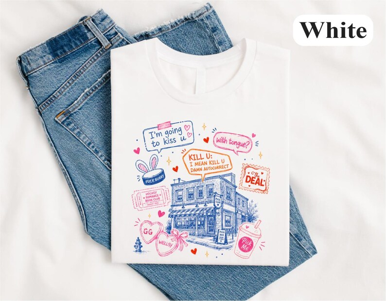 May include: A white t-shirt featuring a blue line-art illustration of a building surrounded by colourful graphic elements, including speech bubbles with text like 'I'm going to kiss u', 'with tongue?', and 'KILL U: I MEAN KILL U DAMN AUTOCORRECT'.