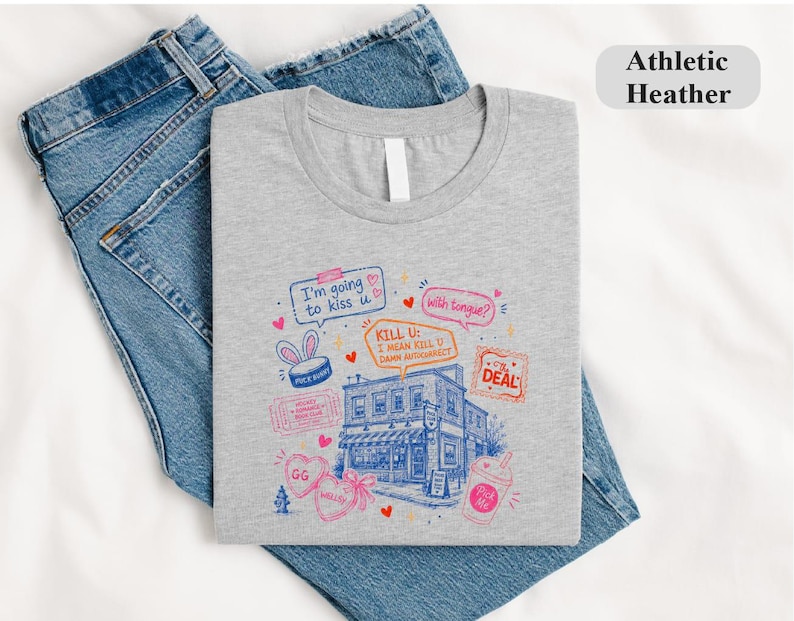 May include: An athletic heather grey t-shirt featuring a blue and pink graphic illustration of a building surrounded by speech bubbles with text including I'm going to kiss u, with tongue?, KILL U: I MEAN KILL U DANN AUTOCORRECT, and The Deal.