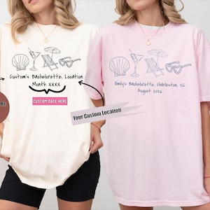 以下が含まれることがあります： ビーチをテーマにしたデザインの、アイボリーとピンクの2枚のTシャツ。アイボリーのシャツには「Custom's Bachelorette, Location, Month xxxx」と「Custom Date Here」と書かれています。ピンクのシャツには「Emily's Bachelorette, Charleston SC, August 2024」と書かれています。