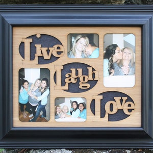 Può includere: Una cornice per foto in legno con una cornice nera e un interno in legno chiaro. La cornice ha sei aperture per foto, ciascuna con un ritaglio delle parole "Live", "Laugh" e "Love".
